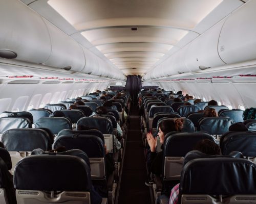 A view of passengers seated inside a commercial airplane cabin during flight.